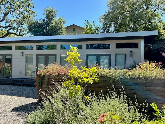 A low mono-pitch modern home with a clerestory window band and glass doors.